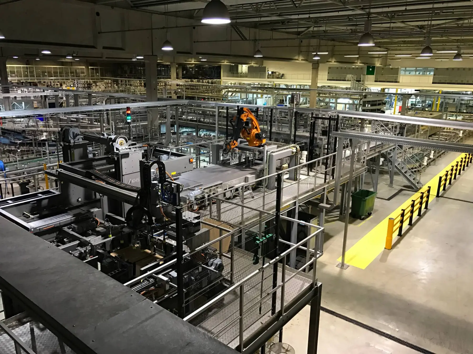 Blick über eine Werkshalle mit Palettierer und Fördertechnik